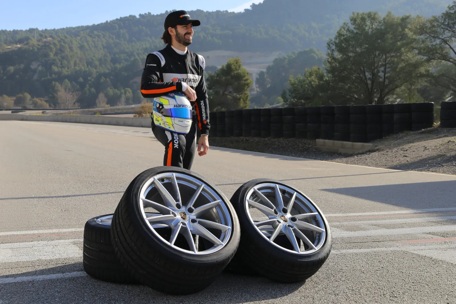 Hankook test driver Aleix Alcaraz posing next to two Porsche alloy wheels fitted with Hankook Ventus S1 evo Z tyres. (Photo: Hankook)